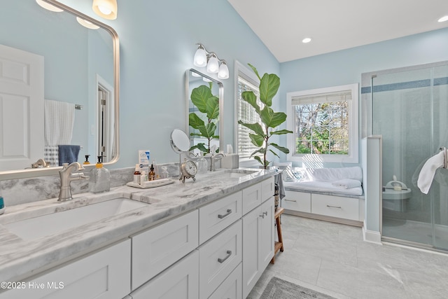 bathroom with walk in shower, vanity, and lofted ceiling