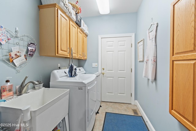 washroom featuring cabinets, sink, and independent washer and dryer