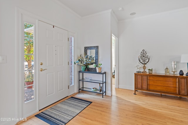 foyer entrance with ornamental molding and hardwood / wood-style flooring