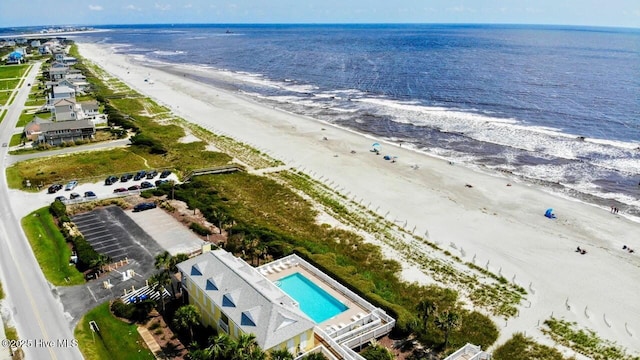 drone / aerial view with a water view and a beach view