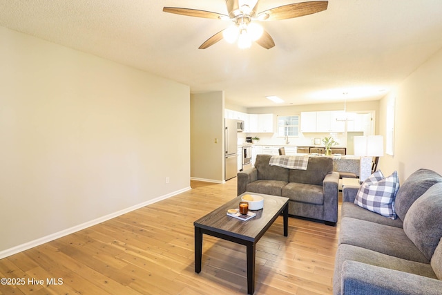 living room with ceiling fan and light hardwood / wood-style floors