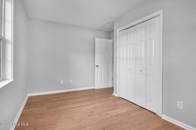 unfurnished bedroom with a closet and light hardwood / wood-style flooring