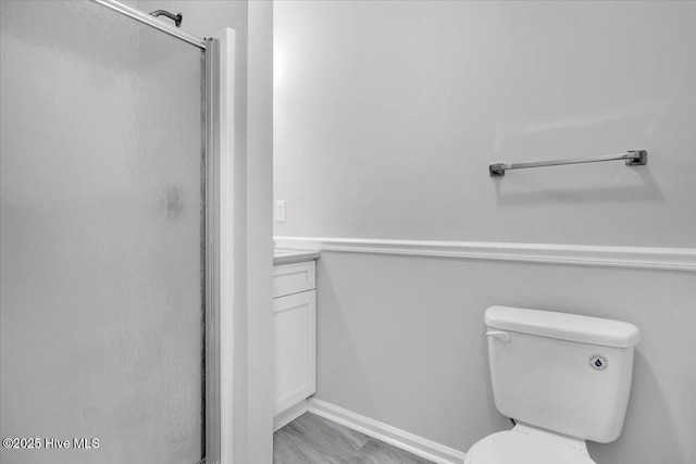 bathroom featuring vanity, an enclosed shower, and toilet