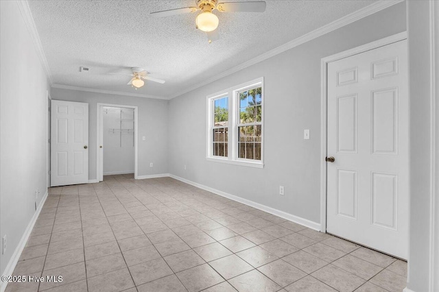 tiled spare room with ceiling fan, crown molding, and a textured ceiling