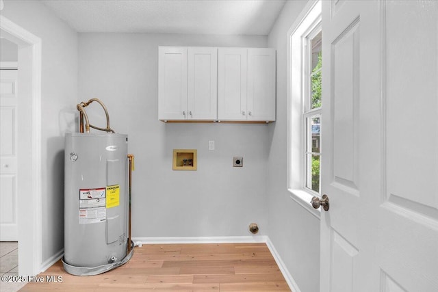 laundry room featuring hookup for an electric dryer, hookup for a washing machine, cabinets, a healthy amount of sunlight, and water heater