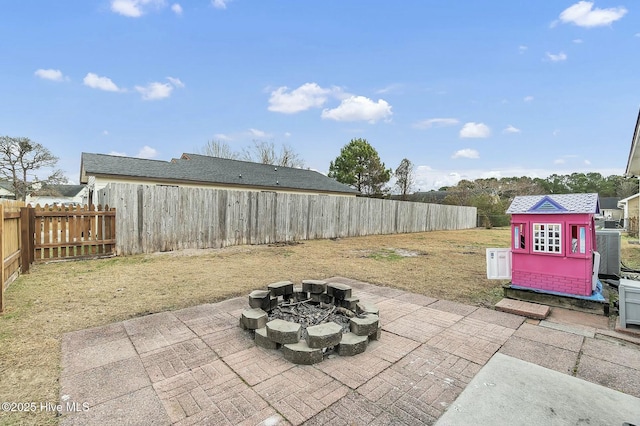 view of patio featuring a storage shed, central air condition unit, and an outdoor fire pit