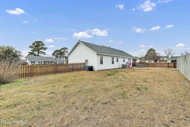 back of property with a yard and central air condition unit