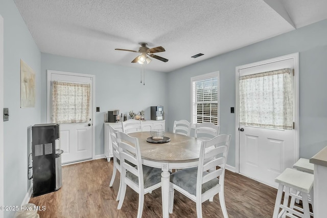 dining area featuring ceiling fan, light hardwood / wood-style floors, and a textured ceiling