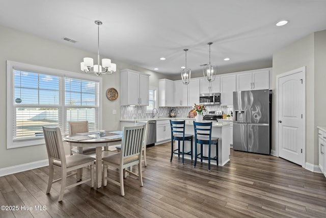 dining room with dark hardwood / wood-style floors, a notable chandelier, and sink