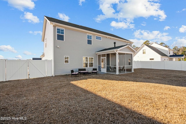 rear view of house featuring a sunroom and a yard