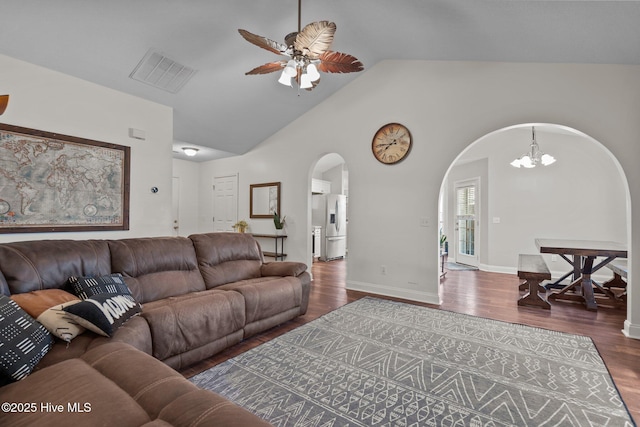 living room featuring ceiling fan with notable chandelier, dark hardwood / wood-style flooring, and lofted ceiling