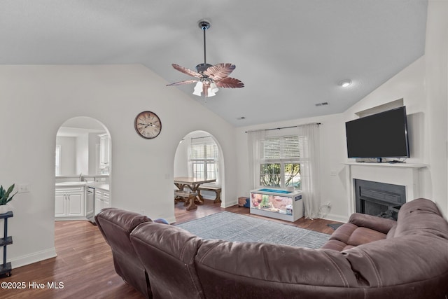 living room with ceiling fan, hardwood / wood-style floors, lofted ceiling, and sink