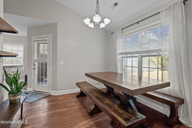 dining room featuring hardwood / wood-style flooring, a notable chandelier, and lofted ceiling