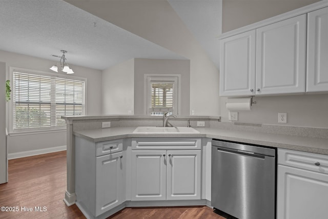 kitchen with dishwasher, sink, kitchen peninsula, a chandelier, and white cabinets