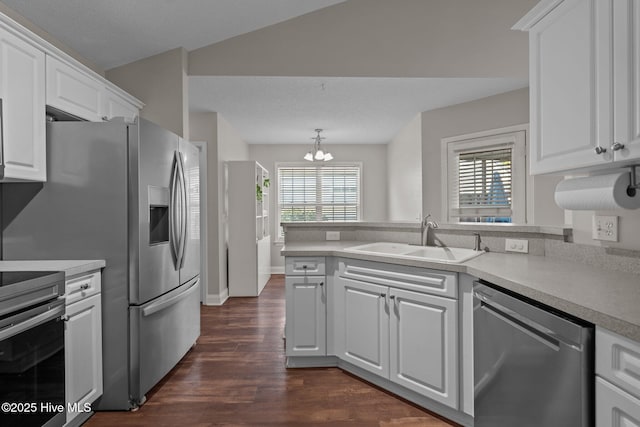 kitchen featuring white cabinets, sink, stainless steel dishwasher, range, and a chandelier