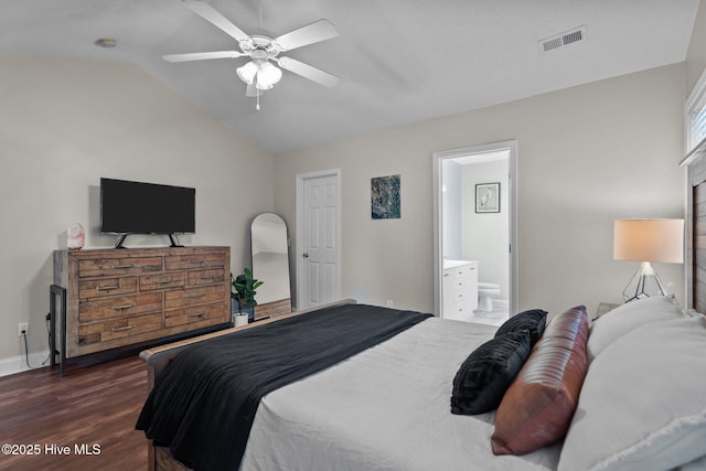 bedroom with ceiling fan, lofted ceiling, dark wood-type flooring, and ensuite bath