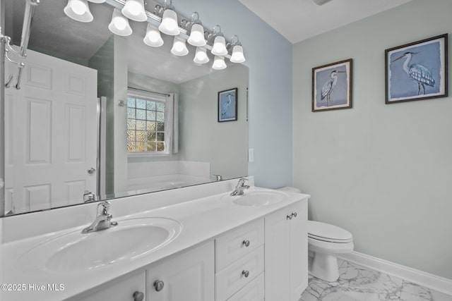 bathroom with a bathtub, vanity, and toilet