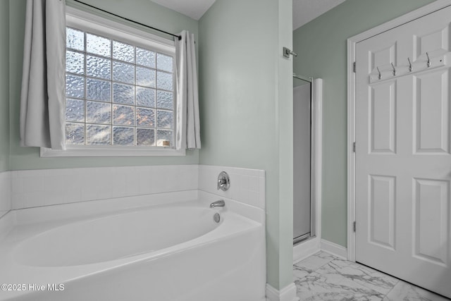 bathroom featuring a textured ceiling, separate shower and tub, and a healthy amount of sunlight