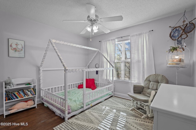 bedroom with hardwood / wood-style flooring, ceiling fan, and a textured ceiling