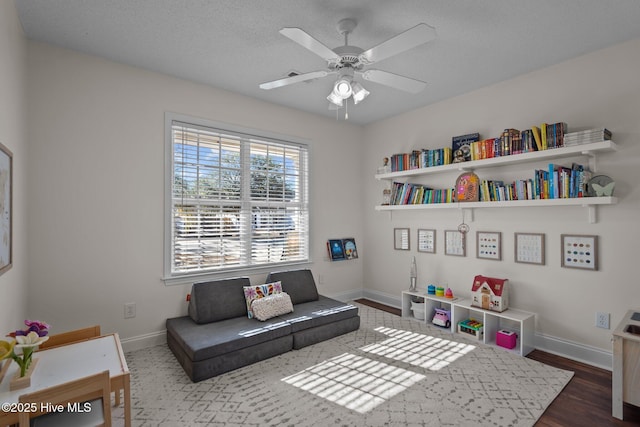 living area featuring dark hardwood / wood-style floors and ceiling fan