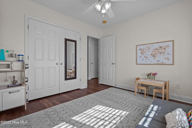 bedroom featuring dark hardwood / wood-style flooring, ceiling fan, a closet, and sink