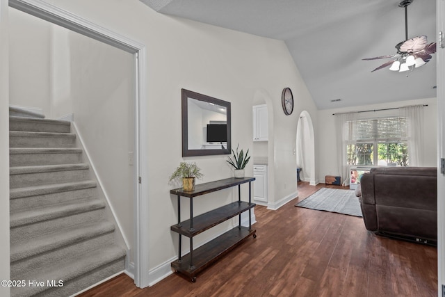 living room featuring ceiling fan, dark hardwood / wood-style flooring, and vaulted ceiling