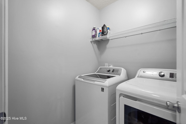 clothes washing area featuring a textured ceiling and separate washer and dryer