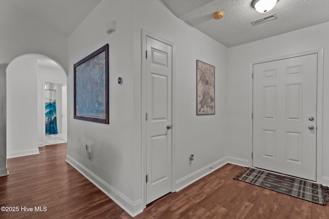 entryway with a textured ceiling and dark wood-type flooring