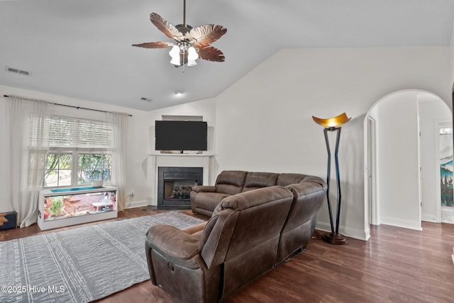 living room featuring vaulted ceiling, ceiling fan, and dark wood-type flooring