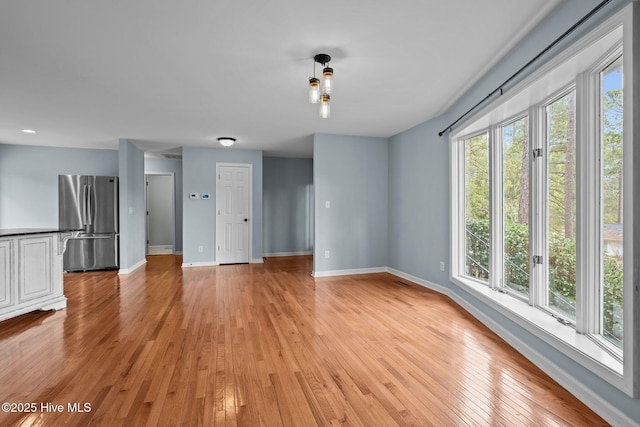 unfurnished living room with light hardwood / wood-style flooring and plenty of natural light