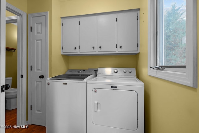 laundry area with dark hardwood / wood-style flooring, cabinets, and independent washer and dryer