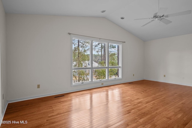 spare room with ceiling fan, light wood-type flooring, and vaulted ceiling