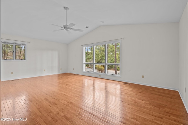 empty room with ceiling fan, light hardwood / wood-style floors, and vaulted ceiling