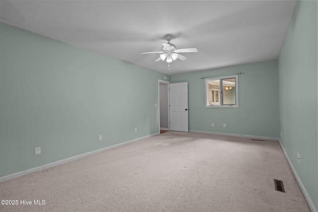 carpeted spare room with ceiling fan