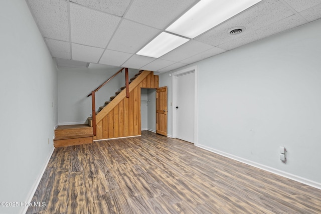 basement featuring dark hardwood / wood-style flooring and a drop ceiling