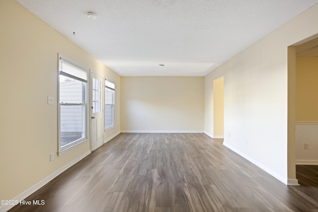 empty room with a textured ceiling and hardwood / wood-style flooring