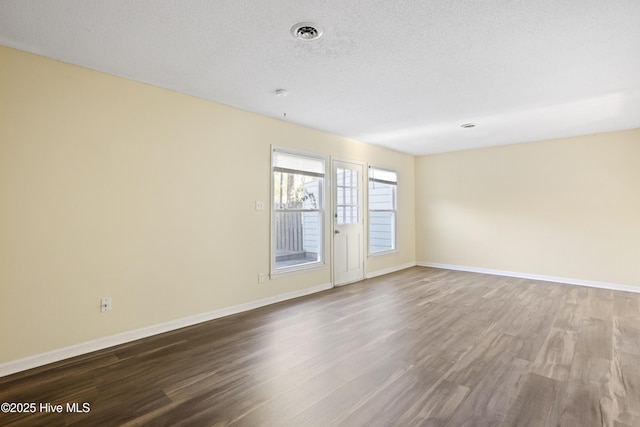 unfurnished room featuring wood-type flooring and a textured ceiling