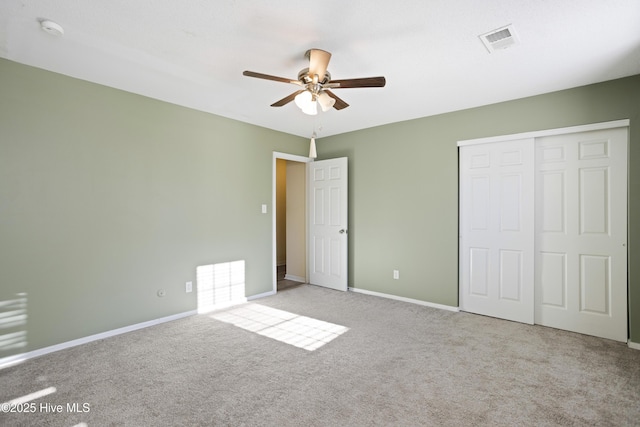 unfurnished bedroom with ceiling fan, light colored carpet, and a closet