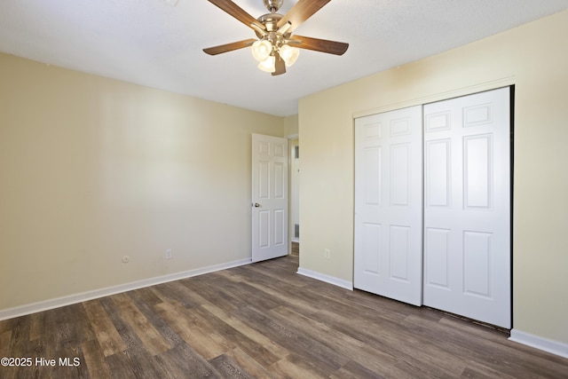 unfurnished bedroom featuring ceiling fan, dark hardwood / wood-style floors, and a closet