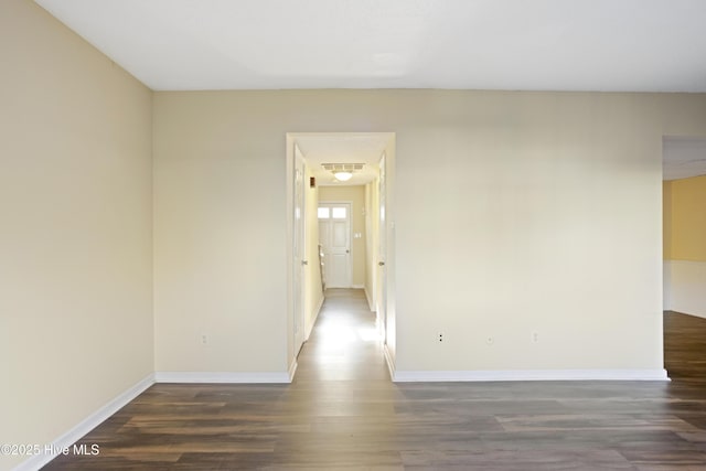 unfurnished room featuring dark wood-type flooring