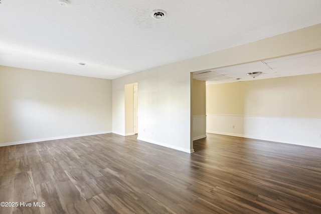 unfurnished room with dark hardwood / wood-style flooring