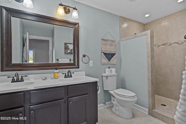 bathroom featuring tile patterned flooring, vanity, toilet, and a tile shower