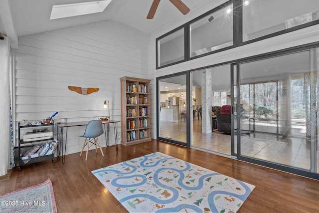 sitting room featuring wood-type flooring, a skylight, high vaulted ceiling, and ceiling fan