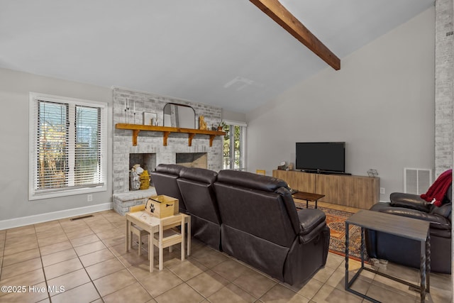 living room with light tile patterned floors, a large fireplace, lofted ceiling with beams, and a healthy amount of sunlight