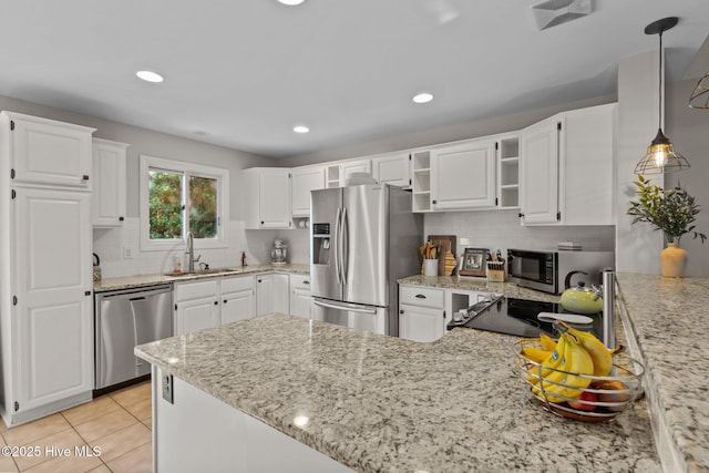 kitchen featuring stainless steel appliances, sink, light tile patterned floors, decorative light fixtures, and white cabinets