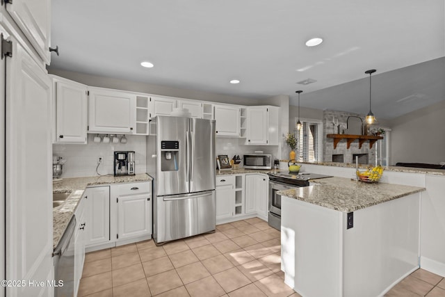 kitchen with kitchen peninsula, appliances with stainless steel finishes, decorative light fixtures, and white cabinetry