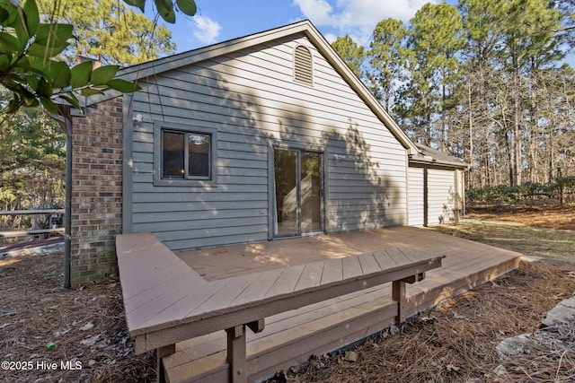 rear view of property featuring a wooden deck