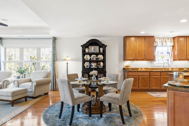 dining space with light wood finished floors and recessed lighting