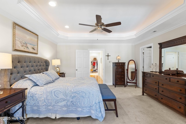 bedroom featuring ornamental molding, light carpet, ceiling fan, and a tray ceiling