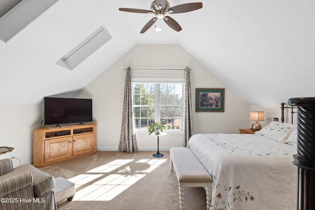 bedroom featuring ceiling fan, lofted ceiling with skylight, carpet flooring, and baseboards